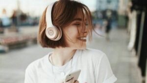 Como sair da bad: menina com fonos de ouvido e dançando na rua