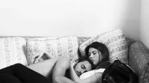 você não estava nos planos. Na imagem um casal abraçado dormindo no sofá.