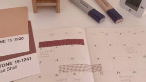 Planner mensal 2023 para imprimir: na imagem o detalhe de um planner de visualização mensal com algumas canetas na composição