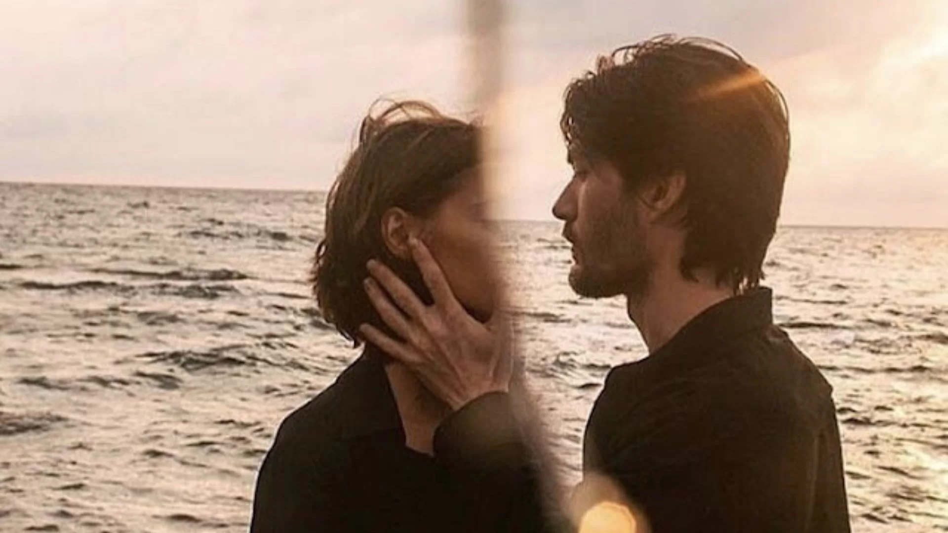 foto de um casal triste com o mar ao fundo.